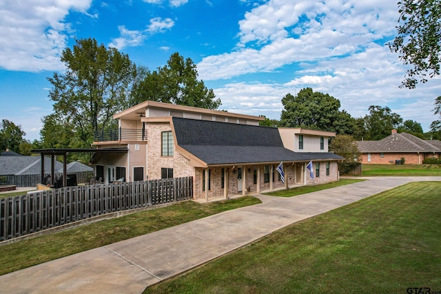 200 County Road 1520, Mount Pleasant, TX 75455 - view of front of home with fence, a shingled roof, a front lawn, covered porch, and brick siding