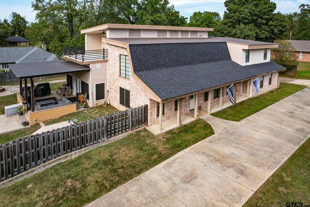 200 County Road 1520, Mount Pleasant, TX 75455 - view of front of property featuring a fenced backyard, a front lawn, brick siding, and a balcony