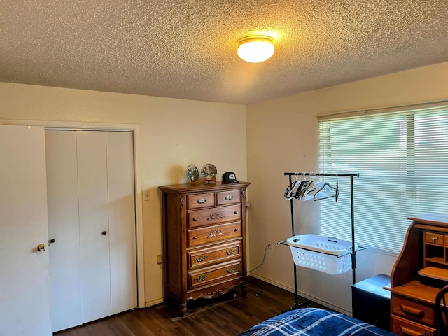219 Lockhart St, Pittsburg, TX 75686 - bedroom featuring dark wood finished floors, a closet, and a textured ceiling