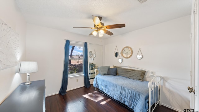 bedroom featuring dark hardwood / wood-style floors, a textured ceiling, and ceiling fan