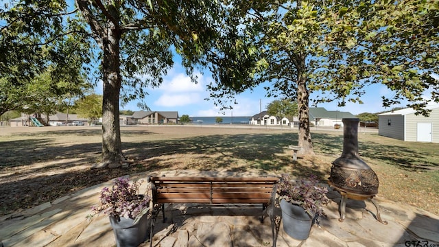 view of yard with a water view, a playground, a patio area, and a fire pit