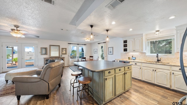 kitchen featuring sink, a center island, pendant lighting, and french doors