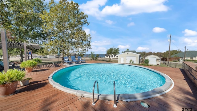 view of pool featuring a wooden deck and a storage shed