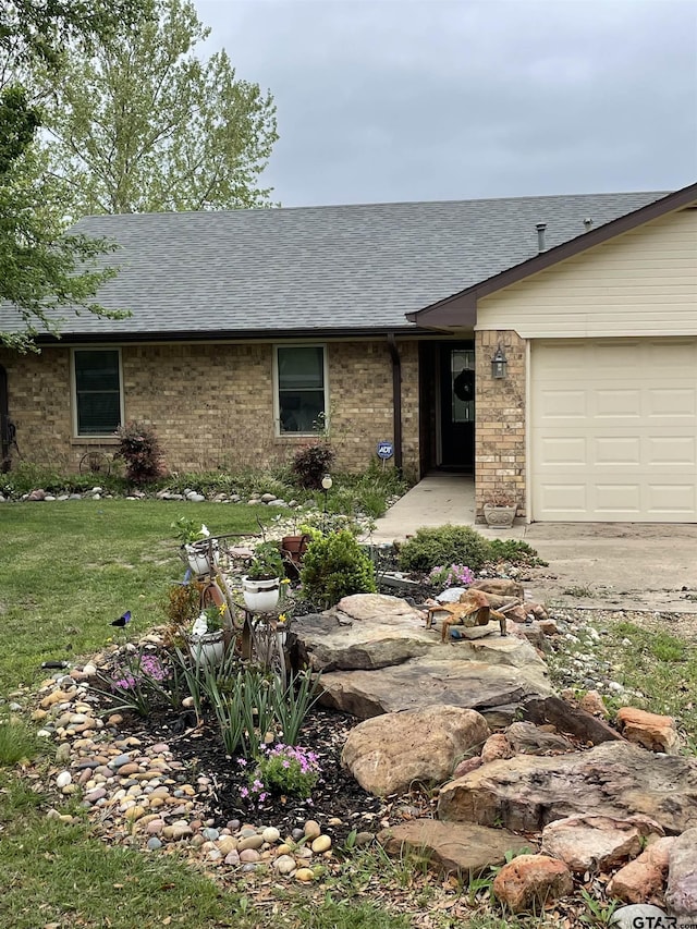 ranch-style house featuring a garage and a front yard