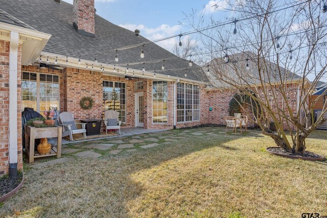 110 Carmel, Bullard, TX 75757 - rear view of house featuring roof with shingles, brick siding, a chimney, and a yard