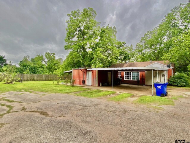 710 N 6th St, Crockett, TX 75835 - view of outdoor structure with an attached carport, fence, and dirt driveway