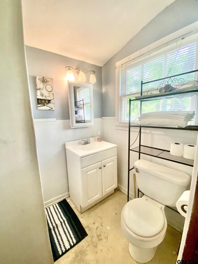 710 N 6th St, Crockett, TX 75835 - half bathroom featuring vanity, baseboards, vaulted ceiling, and toilet