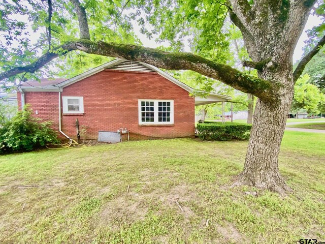 710 N 6th St, Crockett, TX 75835 - view of side of home featuring a lawn and brick siding