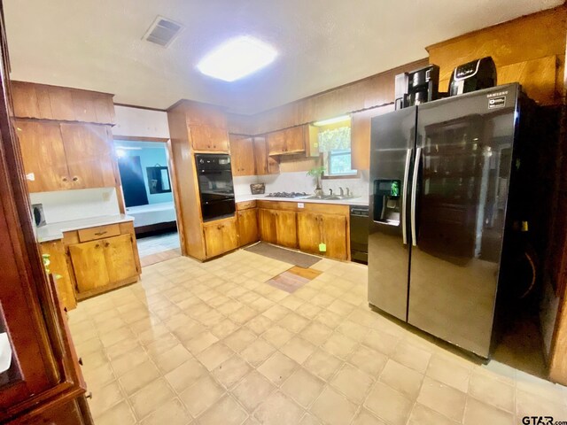 710 N 6th St, Crockett, TX 75835 - kitchen with light countertops, light floors, a warming drawer, and black appliances