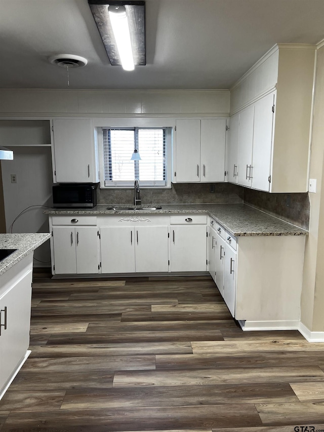 kitchen with a sink, visible vents, dark wood-type flooring, and white cabinets