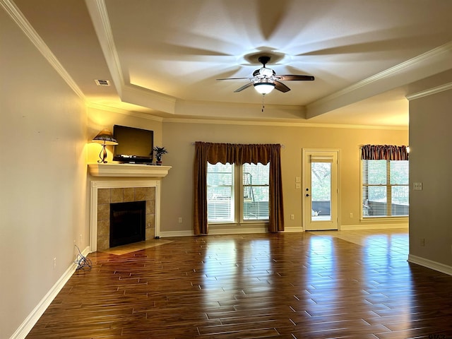 unfurnished living room with visible vents, a raised ceiling, ceiling fan, dark wood-style flooring, and a fireplace