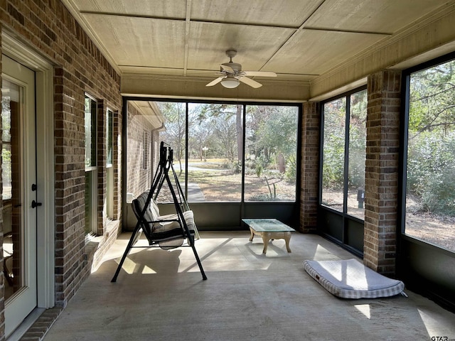 unfurnished sunroom featuring plenty of natural light and a ceiling fan