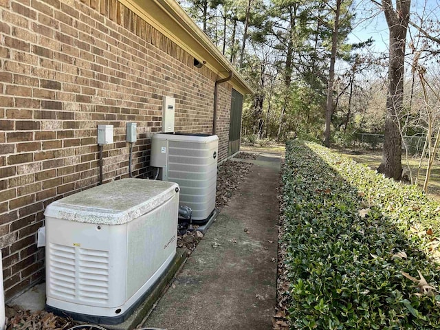 view of side of property featuring brick siding and central air condition unit