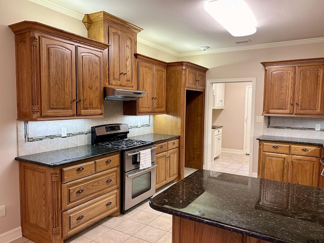 kitchen with tasteful backsplash, visible vents, dark stone countertops, double oven range, and under cabinet range hood