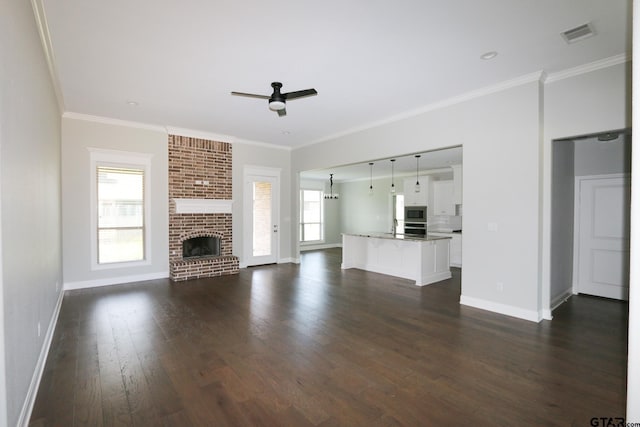 11747 Jayden Ln, Tyler, TX 75703 - unfurnished living room with a ceiling fan, dark wood-style flooring, crown molding, and a fireplace