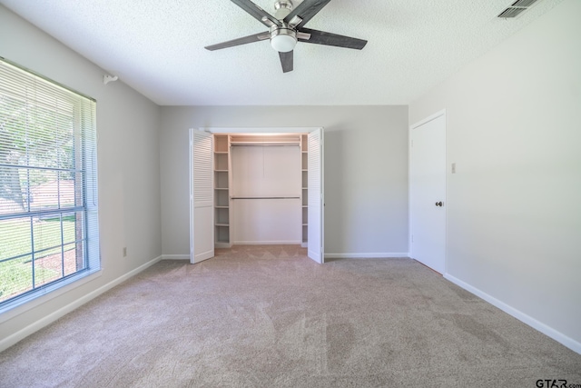 902 Joel Dr, Tyler, TX 75703 - unfurnished bedroom with multiple windows, a textured ceiling, carpet floors, and a closet