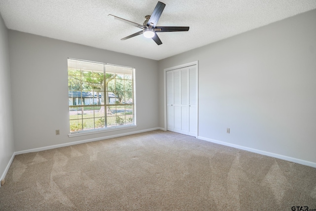 902 Joel Dr, Tyler, TX 75703 - unfurnished bedroom featuring carpet flooring, a textured ceiling, baseboards, a closet, and ceiling fan