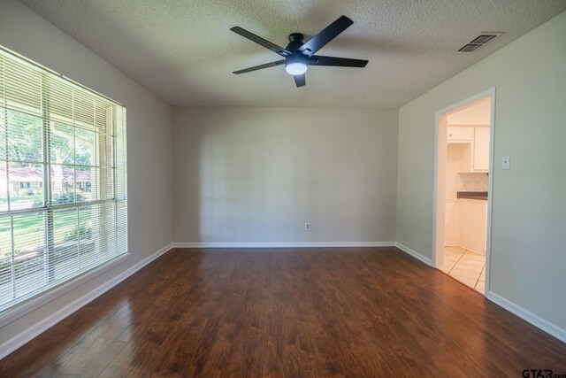 902 Joel Dr, Tyler, TX 75703 - empty room with plenty of natural light, wood finished floors, ceiling fan, and a textured ceiling