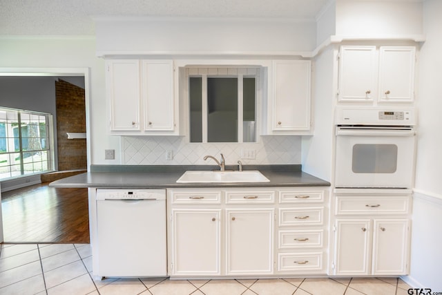 902 Joel Dr, Tyler, TX 75703 - kitchen with white appliances, a sink, dark countertops, white cabinets, and ornamental molding