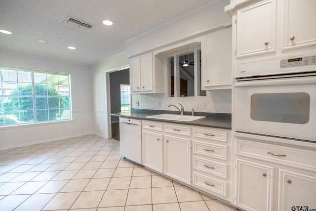 902 Joel Dr, Tyler, TX 75703 - kitchen featuring white appliances, a sink, dark countertops, tasteful backsplash, and light tile patterned floors