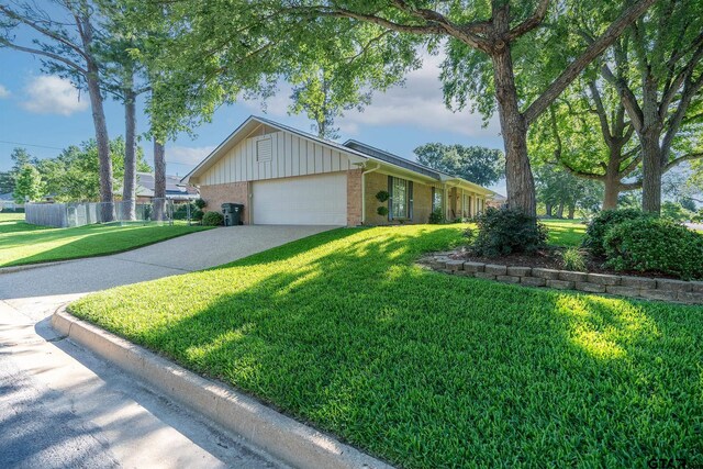 902 Joel Dr, Tyler, TX 75703 - single story home with an attached garage, board and batten siding, brick siding, and concrete driveway