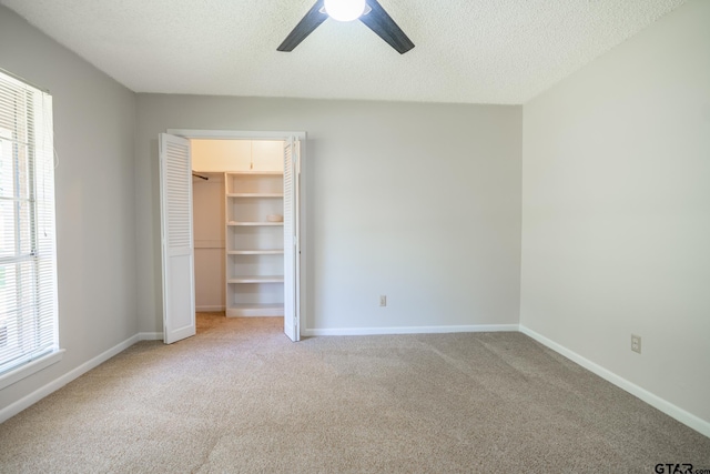 902 Joel Dr, Tyler, TX 75703 - unfurnished bedroom featuring multiple windows, light colored carpet, baseboards, and a textured ceiling