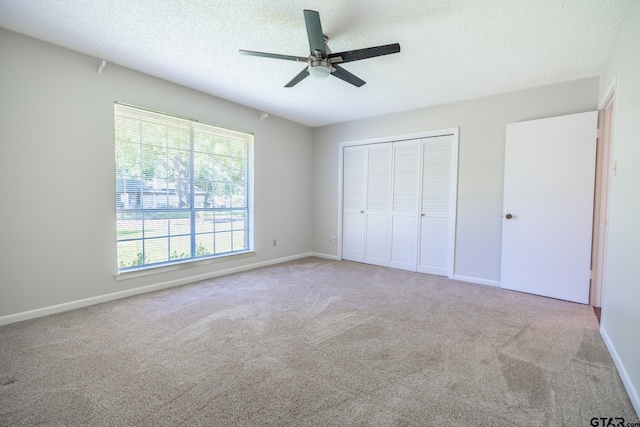 902 Joel Dr, Tyler, TX 75703 - unfurnished bedroom with a textured ceiling, carpet flooring, a closet, ceiling fan, and baseboards
