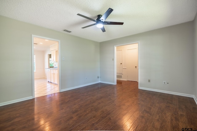 902 Joel Dr, Tyler, TX 75703 - empty room with ceiling fan, wood finished floors, baseboards, and a textured ceiling