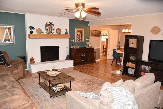 607 Brookhollow Dr, Palestine, TX 75801 - living room with ceiling fan, ornamental molding, wood finished floors, and a brick fireplace