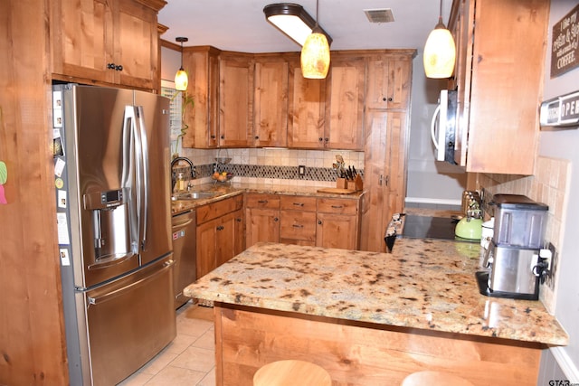 607 Brookhollow Dr, Palestine, TX 75801 - kitchen featuring stainless steel appliances, a sink, tasteful backsplash, a peninsula, and light stone countertops