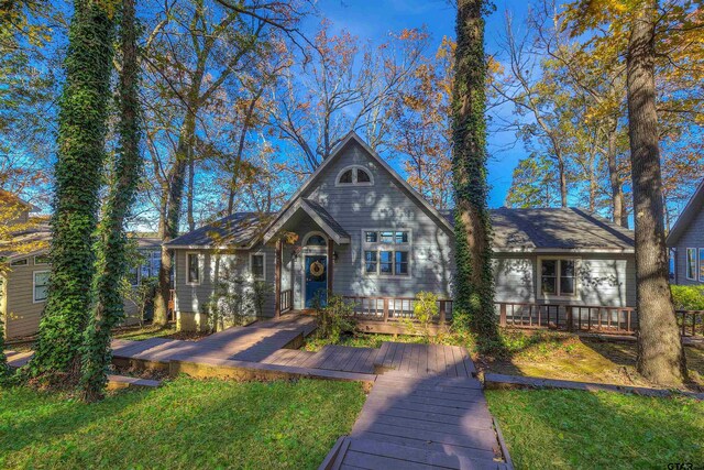 view of front facade featuring a wooden deck and a front yard