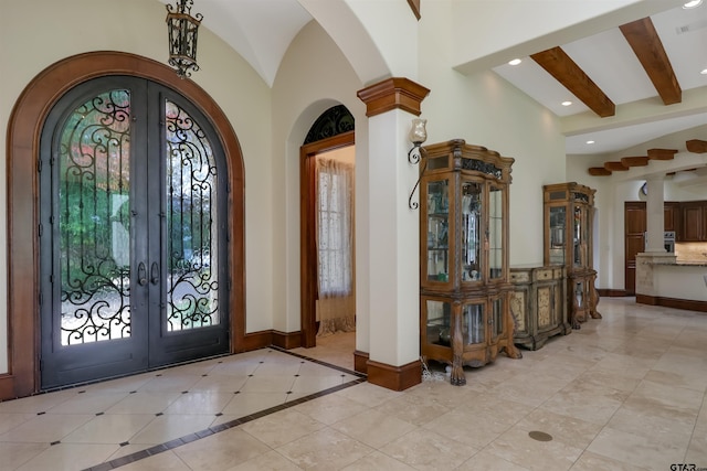 tiled foyer entrance with high vaulted ceiling, beamed ceiling, french doors, and a healthy amount of sunlight