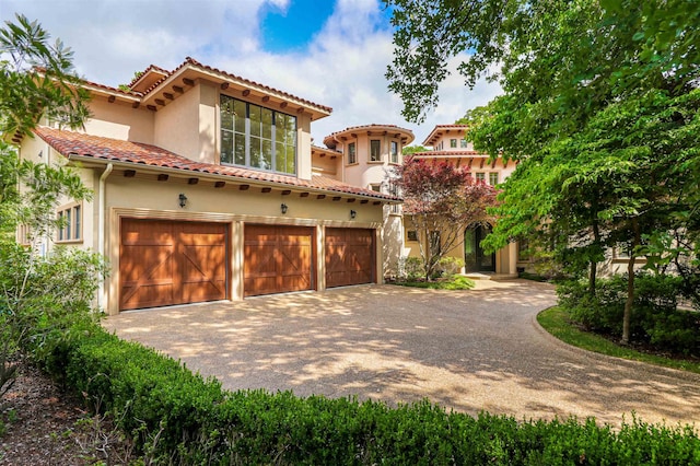 mediterranean / spanish home featuring a garage