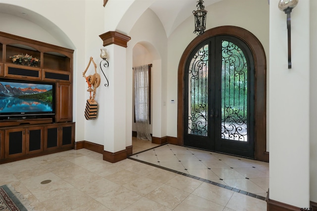 entrance foyer with french doors, vaulted ceiling, and light tile patterned floors