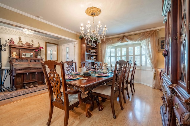 dining room with light hardwood / wood-style flooring, ornamental molding, and an inviting chandelier