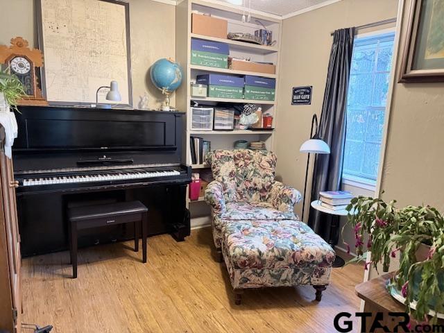 sitting room with light hardwood / wood-style floors and ornamental molding