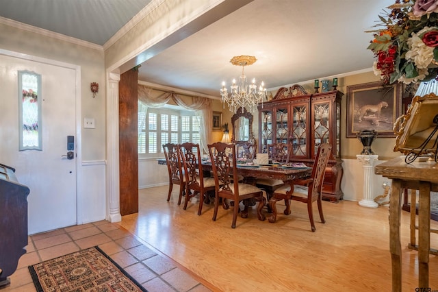 dining space featuring light wood-type flooring, a chandelier, and crown molding