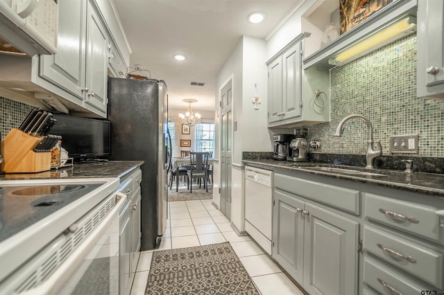 kitchen with white appliances, sink, gray cabinets, a notable chandelier, and light tile patterned floors