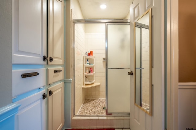 bathroom featuring a shower with door