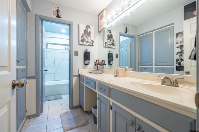 bathroom with tile patterned flooring, tiled shower / bath, and vanity