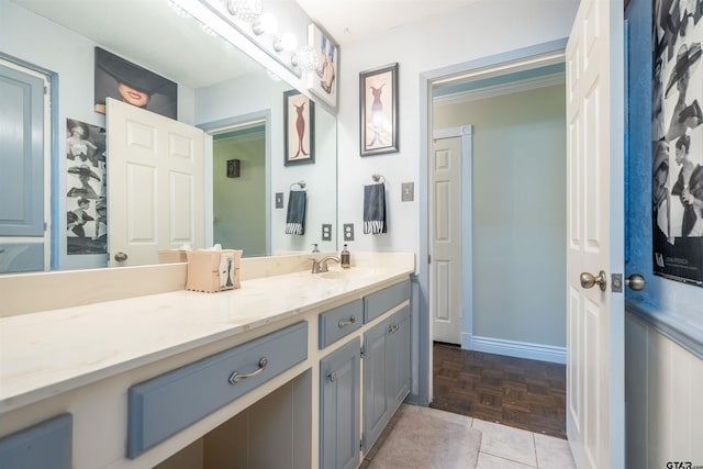 bathroom with ornamental molding, vanity, and parquet floors