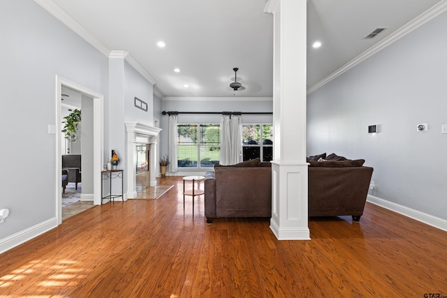 5201 Whitaker Cir, Longview, TX 75605 - living area with decorative columns, wood finished floors, crown molding, a glass covered fireplace, and recessed lighting