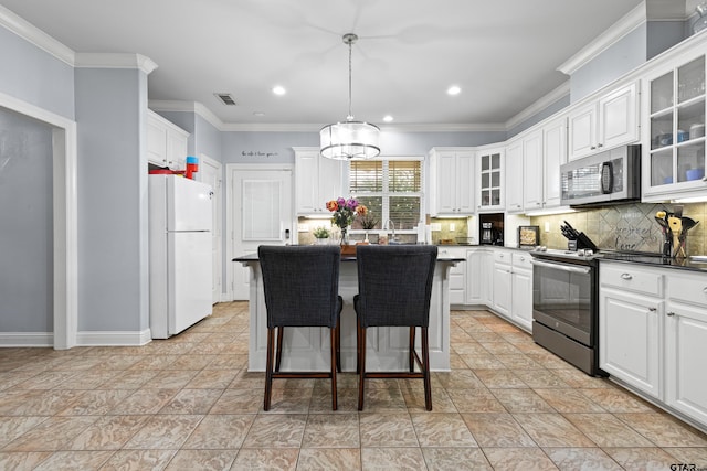 5201 Whitaker Cir, Longview, TX 75605 - kitchen with appliances with stainless steel finishes, dark countertops, backsplash, white cabinets, and crown molding