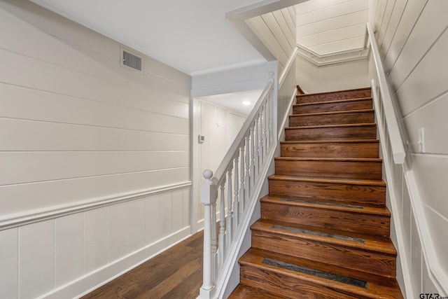 staircase with visible vents and wood finished floors