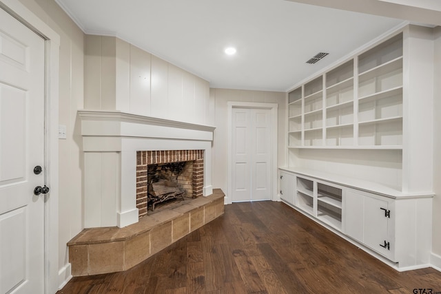 unfurnished living room featuring a fireplace, dark wood-style floors, visible vents, and ornamental molding