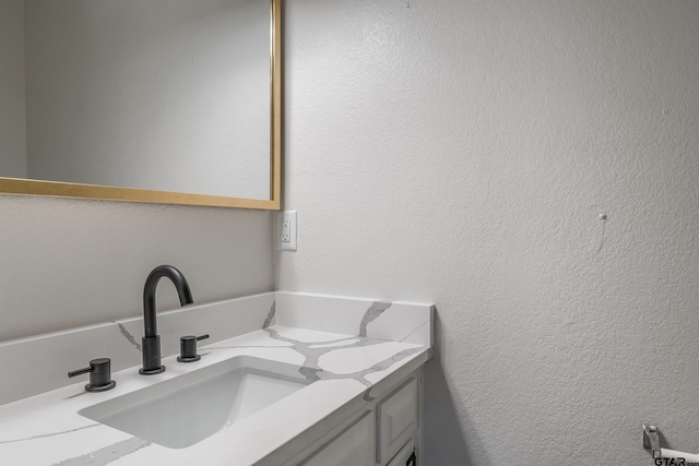 bathroom featuring vanity and a textured wall