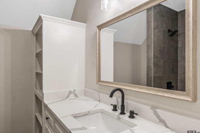 full bath with tiled shower and vanity