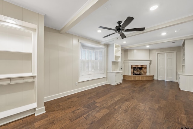 unfurnished living room with beamed ceiling, a fireplace with raised hearth, a ceiling fan, wood finished floors, and baseboards