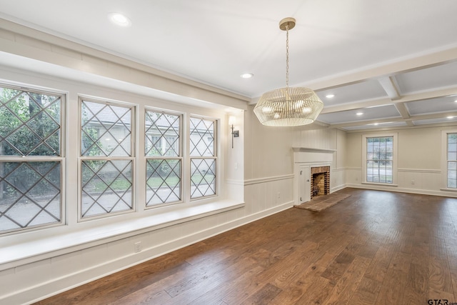 unfurnished living room featuring beamed ceiling, dark wood-type flooring, wainscoting, and coffered ceiling