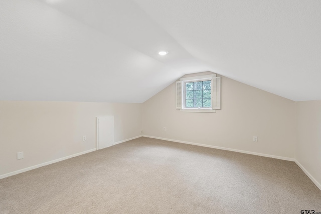 additional living space with vaulted ceiling, carpet flooring, and baseboards